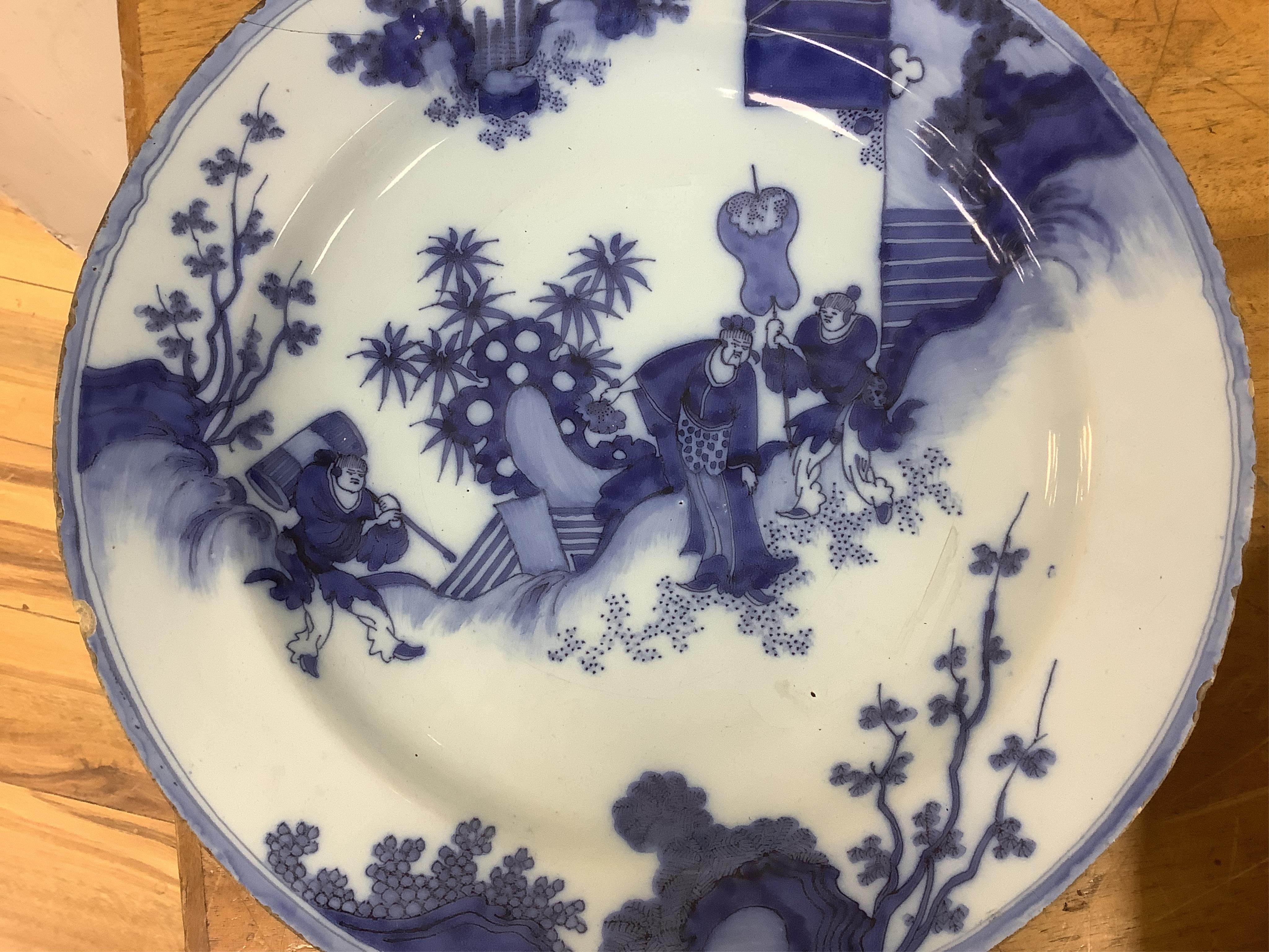 An 18th century English delftware ‘Chinese figures’ dish and two similar Delft dishes, largest 39cm diameter (3), largest 39cm